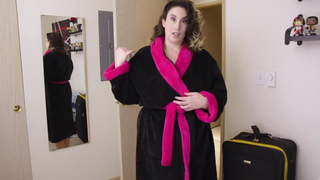 Une brune aux formes généreuses pose devant la caméra et joue avec ses seins.